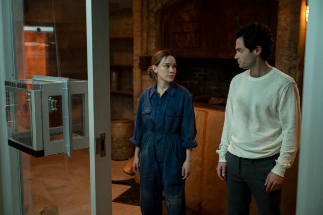 Na foto, Victoria Pedretti e Penn Badgley, que estão se olhando, estrelam nova temporada de You