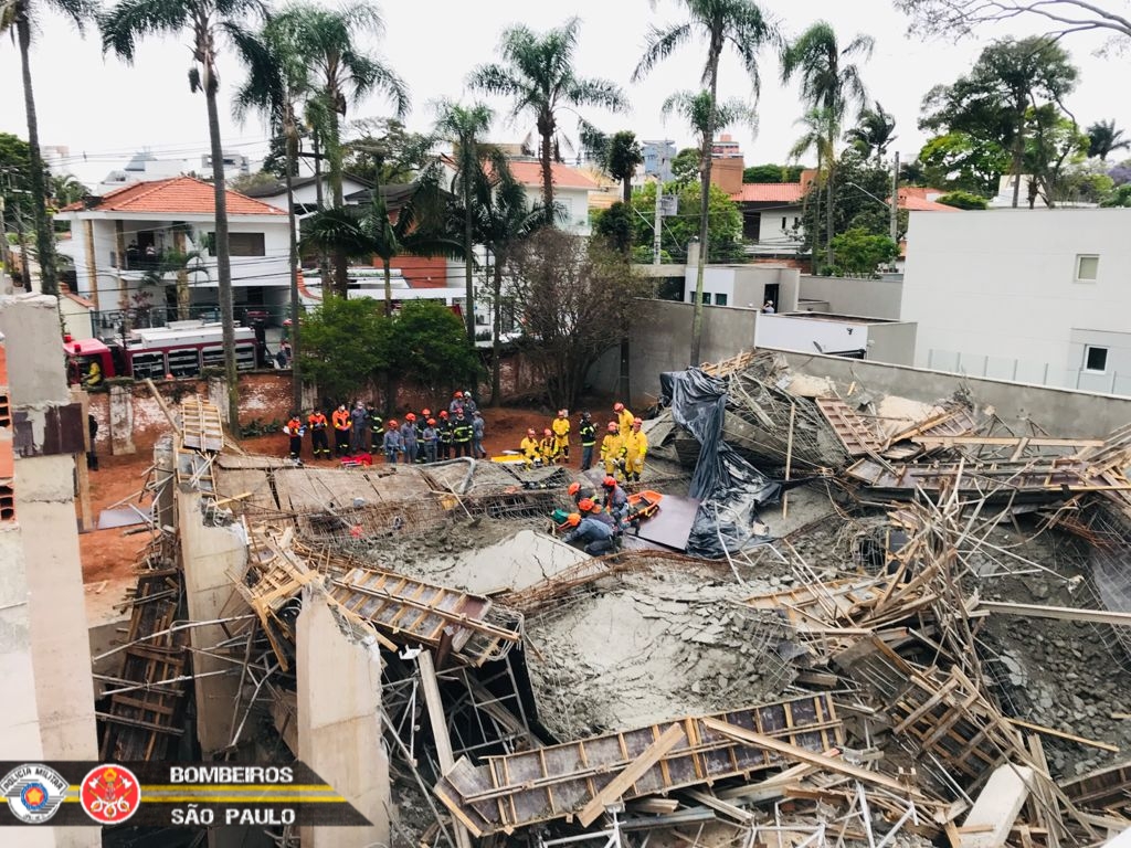 Imagem mostra bombeiros em cima de escombros tentando resgatar vítima em terreno de obras