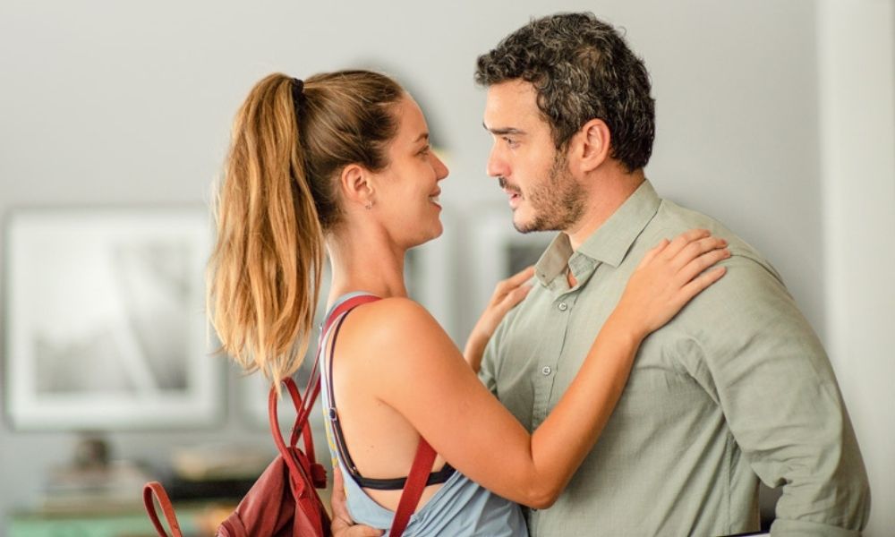 A imagem mostra Nathalia Dill e Marcos Veras, frente a frente. Ela está com as mãos sobre os ombros dele, sorrindo, enquanto ele está com uma cara de surpreso.