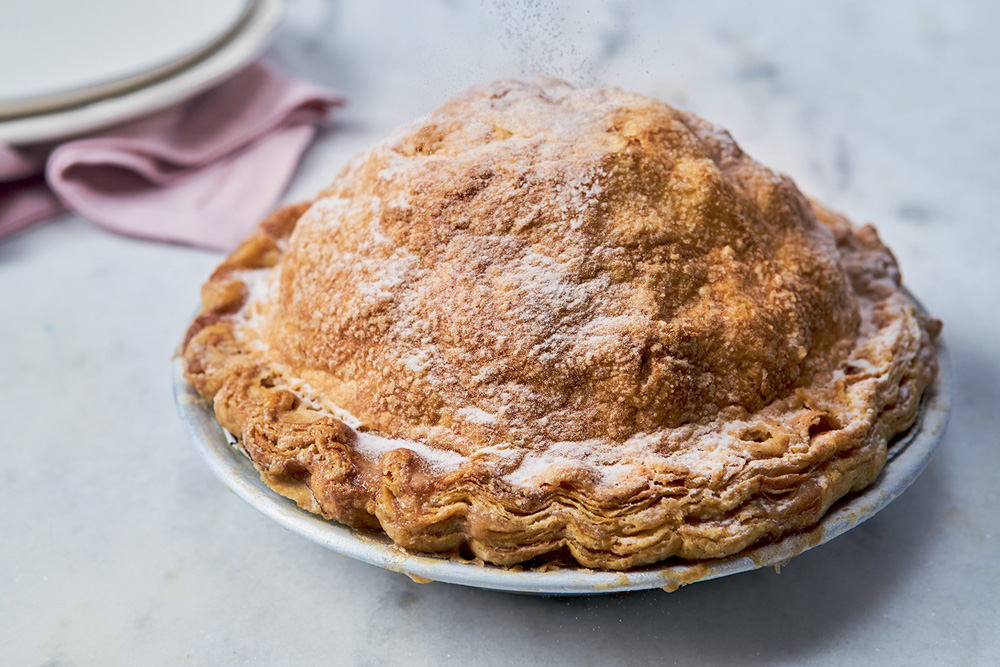 Torta de maçã do Ráscal polvilhada de açúcar sobre assadeira metálica.
