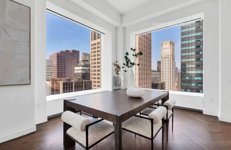 sala-de-jantar-432-park-avenue-arranha-céu-milionário-manhattan-problemas-processo-judicial Sala de jantar com mesa e cadeiras e com duas janelas gigantes nas paredes