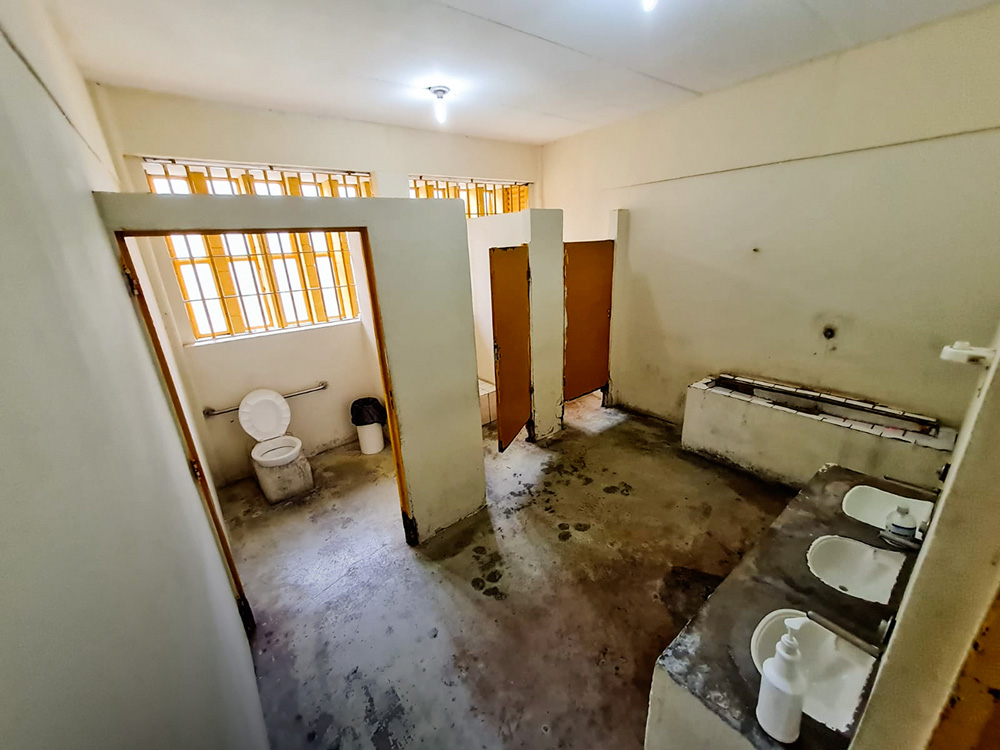 Banheiro Fundação Casa A imagem mostra um banheiro sujo, com três boxes e o chão quase todo preto.