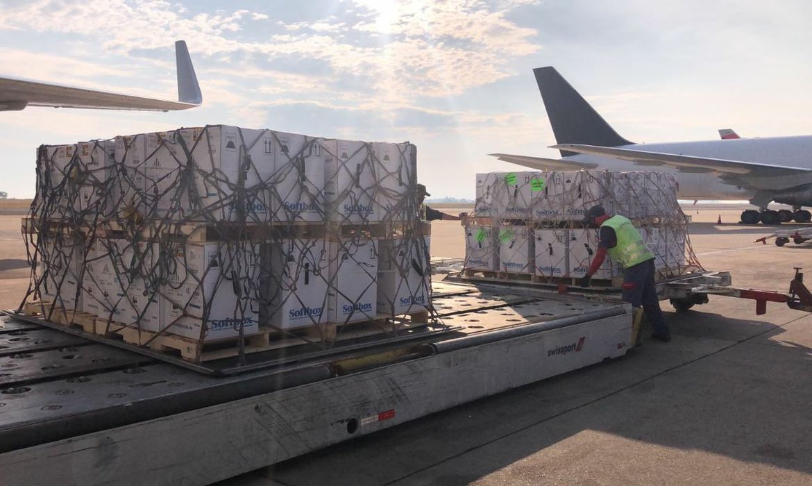 Imagem exibe carregamento de vacinas em aeroporto.