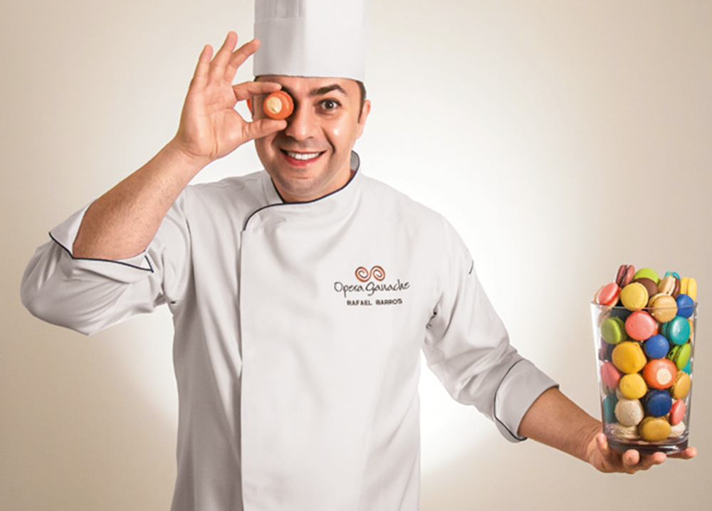 Rafael Barros posa junto de um vidro cheio de macarons