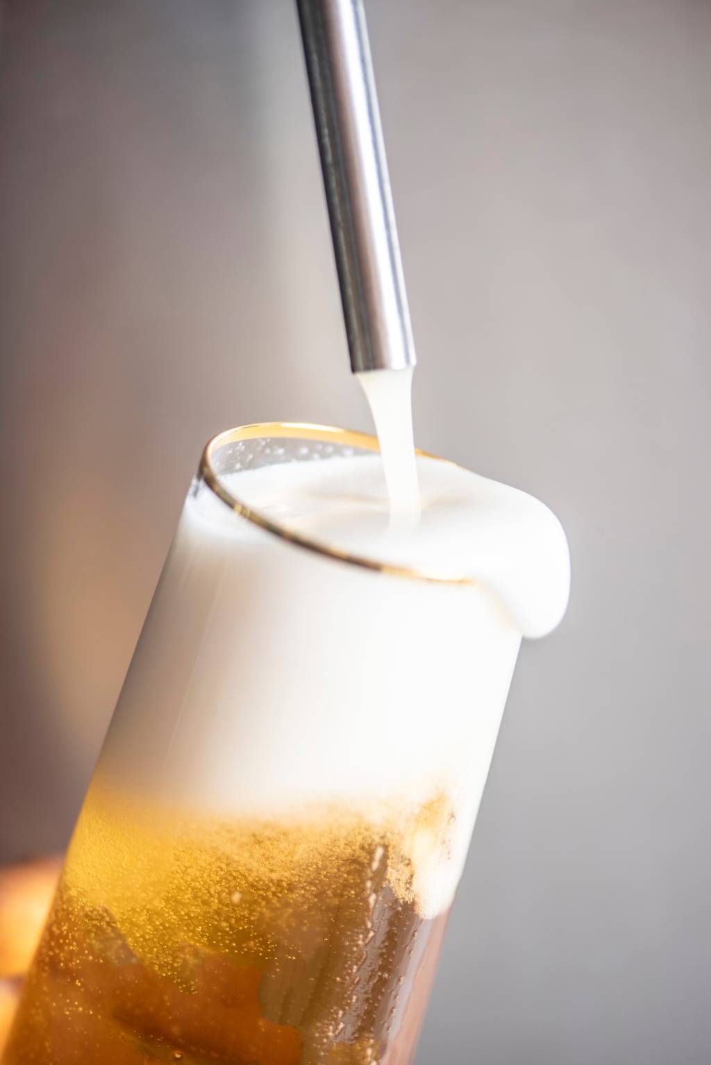 Comer & Beber 2021 – Cervejaria Dogma Chope claro sendo servido em copo de vidro com parte da espuma transbordando.