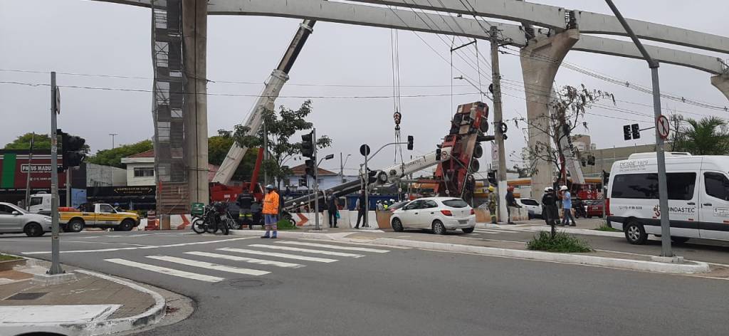 Guindaste Tombado Vila Prudentes Quints A imagem mostra um guindaste, inclinado com a parte da frente no chão, e as rodas suspensas no ar.
