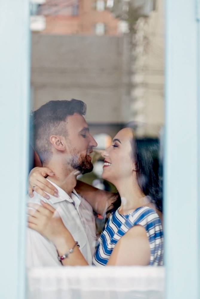 beijo-janela-nosso-louco-amor-mayara-bruno-juntos-desde-os-13-anos-influenciadores-digitais-decoração mayara e bruno sendo fotografados do lado de fora de uma janela. eles estão abraçados com os rostos quase colados um no outro e estão sorrindo