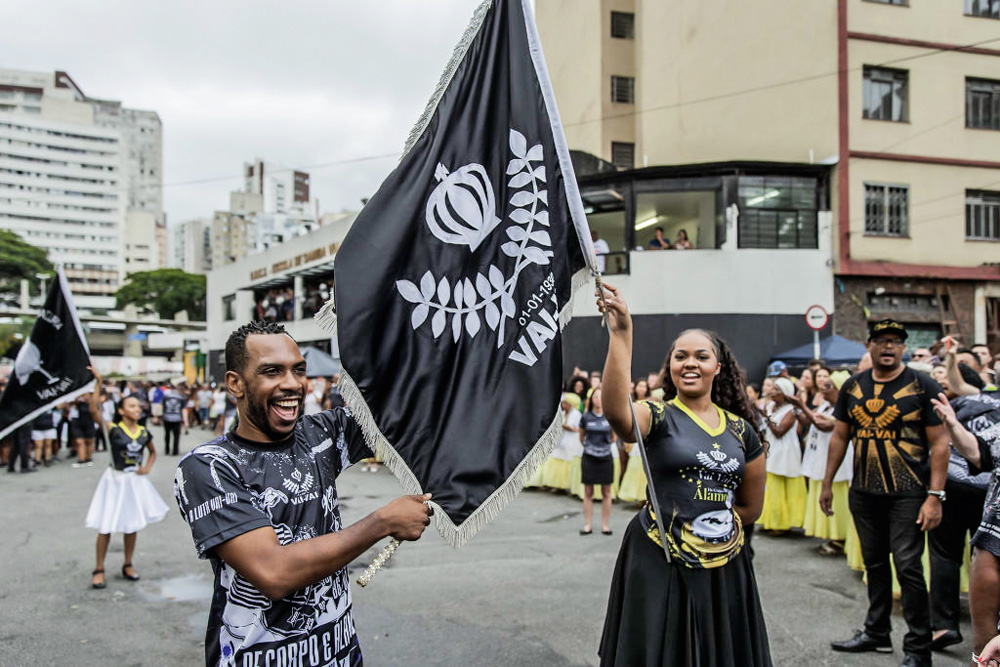 mestre-sala e porta bandeira ensaiando na rua com bandeira da vai-vai