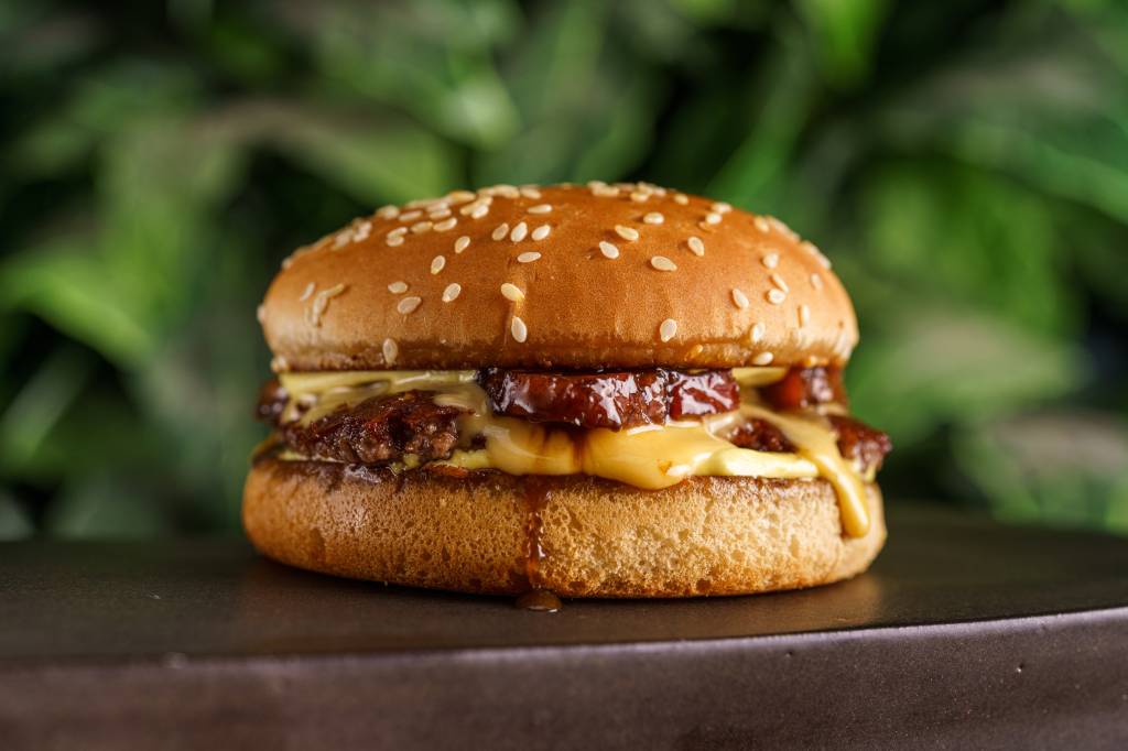 Jurassic Park Burger Restaurant Cheese bacon servido no Jurassic Park Burger Restaurant composto de pão com gergelim branco, queijo e carne