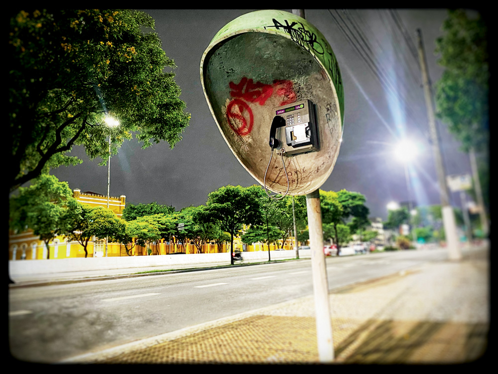 memória-50-anos-orelhões-desaparecendo-vandalismo foto de orelhão vandalisado em rua deserta da cidade