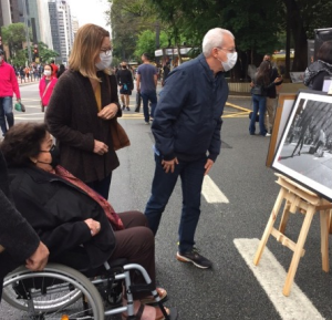 Pessoas olhando retratos, que são parte da exposição Arte Na Rua, que acontece na Avenida Paulista