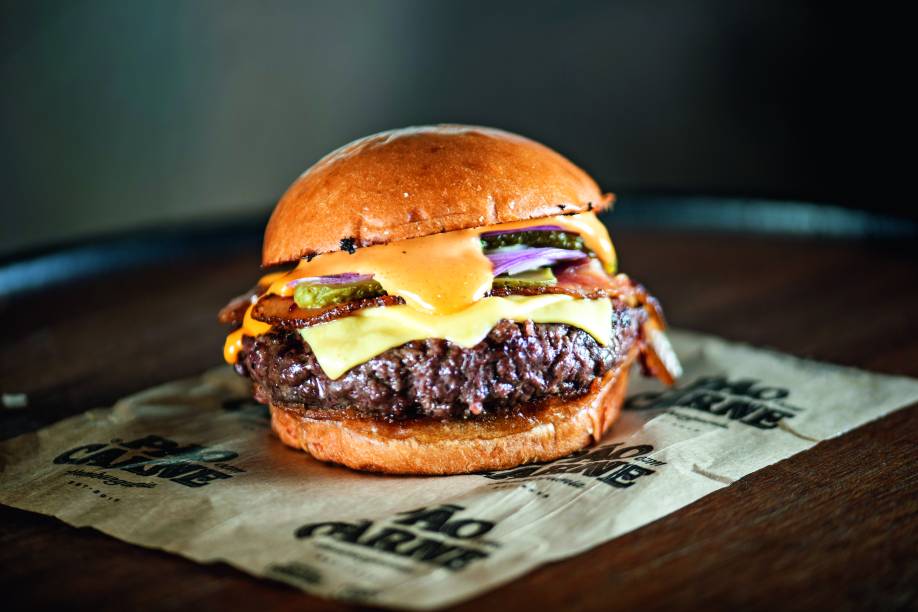 Especial: versão mais parruda com bacon, cebola-roxa, picles de pepino, queijo americano e maionese de páprica Especial: versão mais parruda com bacon, cebola-roxa, picles de pepino, queijo americano e maionese de páprica