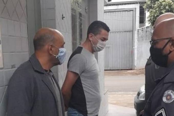 Imagem mostra ex-jogador Piá, de máscaras e camiseta clara, algemado e cabisbaixo
