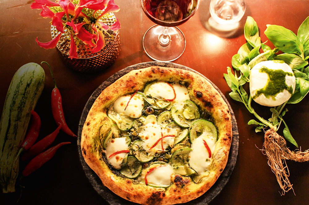Mesa de madeira com pizza individual.
