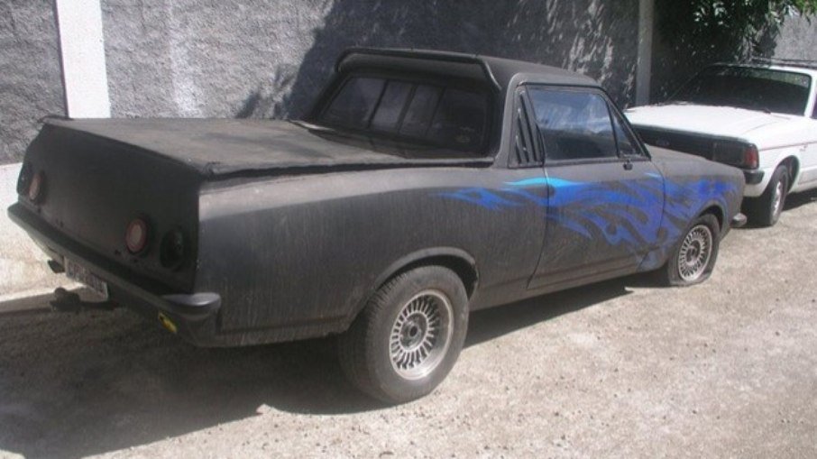opala reformado Imagem mostra um carro preto com chamas azuis pintadas nas laterais.