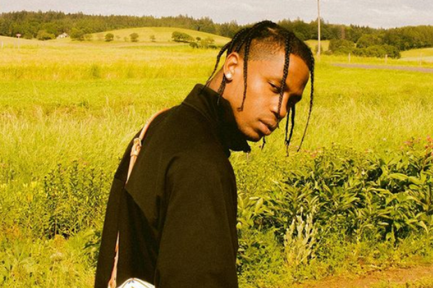 O rapper norte-americano Travis Scott aparece centralizado em um campo aberto