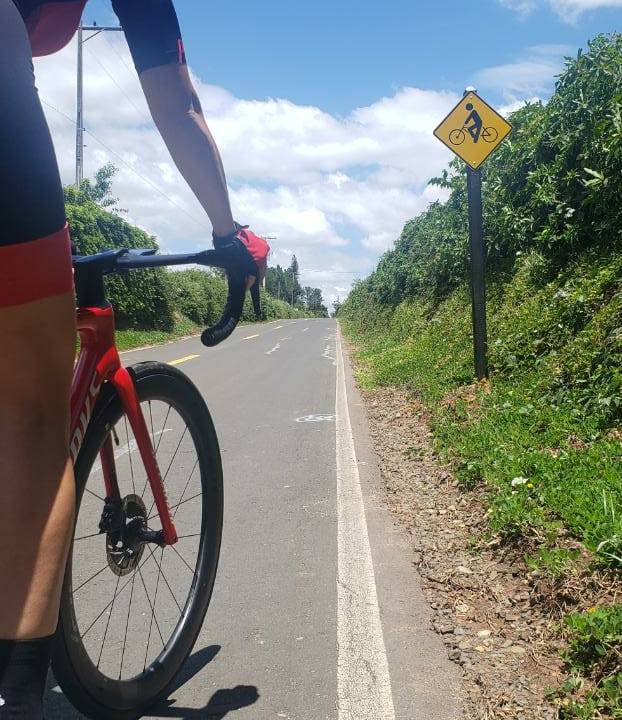 Imagem mostra mulher em cima de bicicleta pedalando em uma ciclorrota
