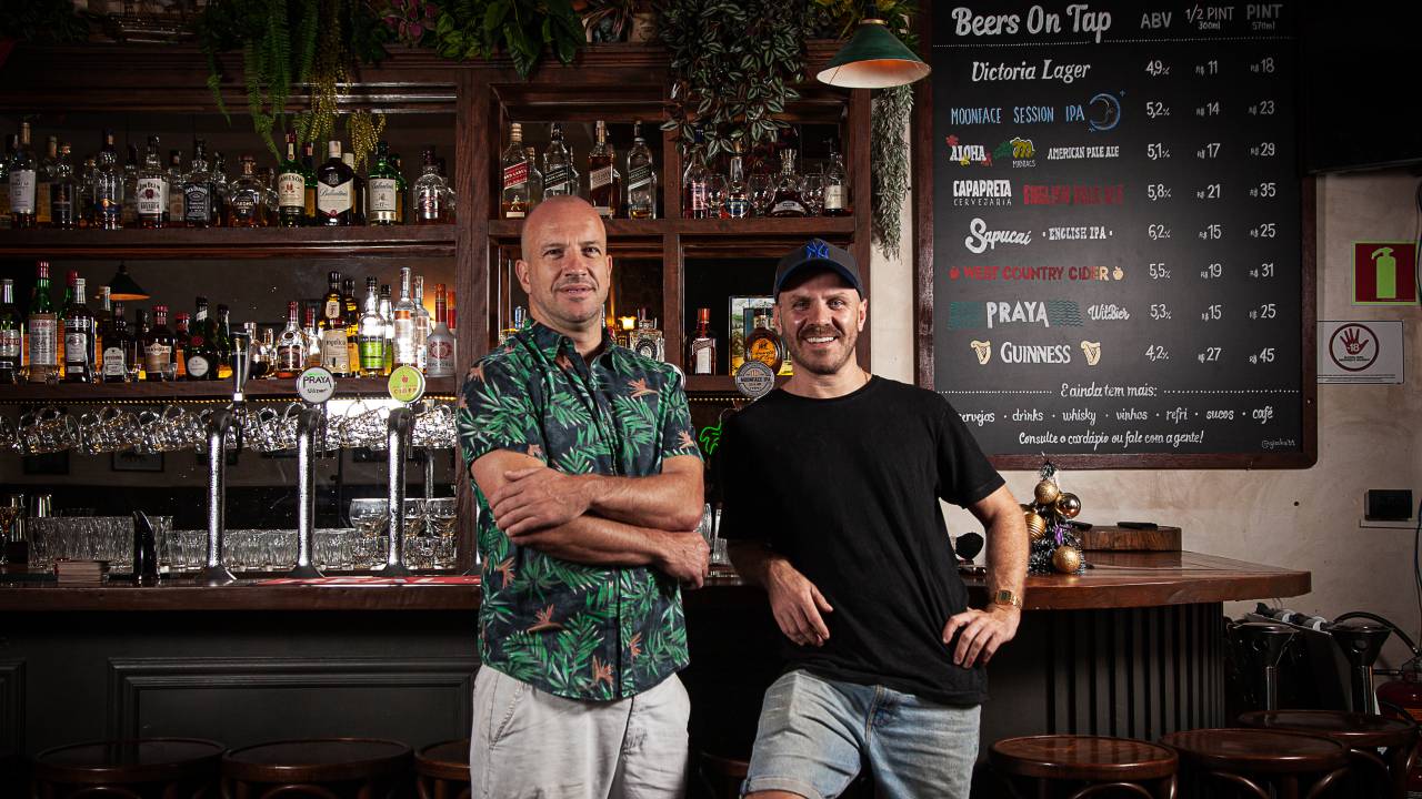 Os sócios Naeem Scarr e Tim Chamberlain, do pub The Victoria, em frente ao balcão do bar.