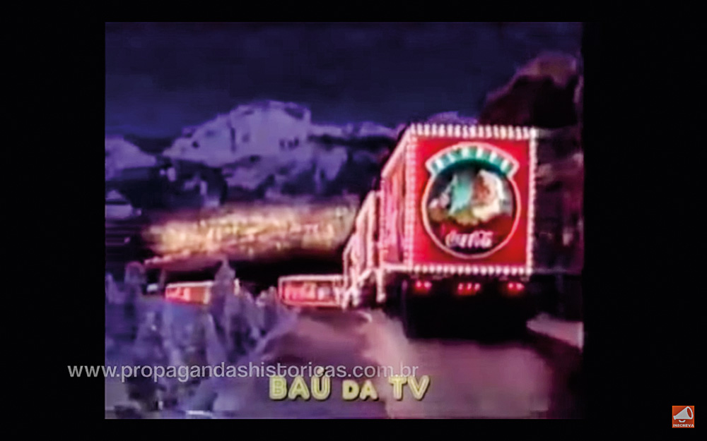 Screen Shot 2021-12-15 at 13.50.50.png Um trenó voador da Coca-Cola paira sobre casas e montanhas, em um comercial natalino antigo da marca.