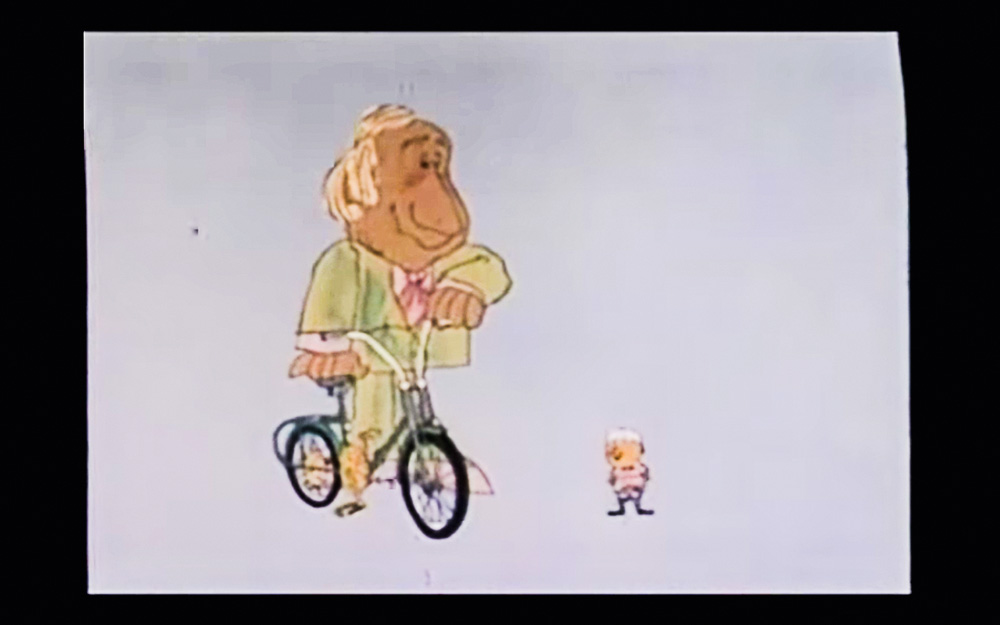 Screen Shot 2021-12-15 at 13.54.11.png Desenho de um homem em uma bicicleta ao lado de um homenzinho menor. A animação é de um comercial antigo.