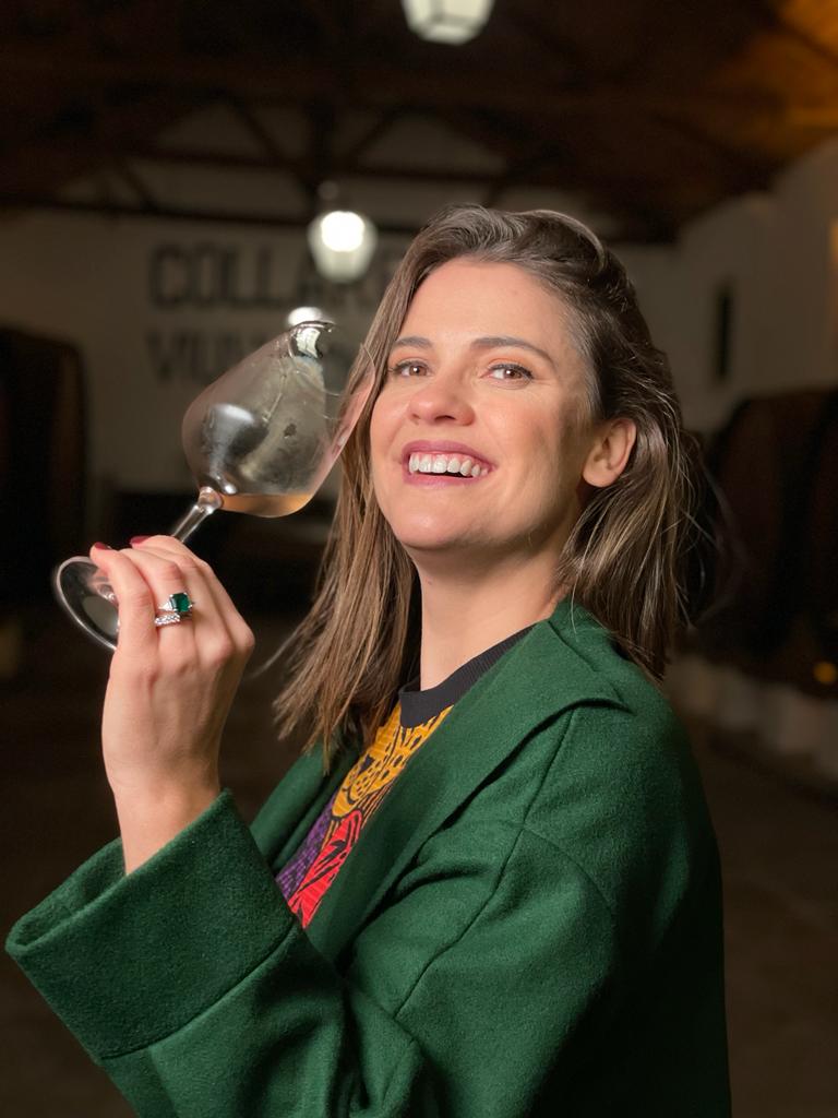 CNN Séries Originais – Vinhos de Portugal: Tradição e Tecnologia A apresentadora Elisa Veeck posa sorrindo e segurando uma taça de vinho