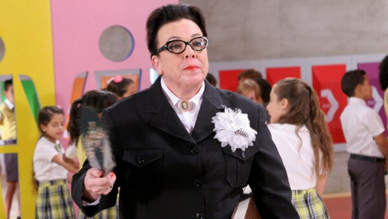 A imagem mostra a atriz Noemi Gerbelli no papel de diretora na novela Carrossel