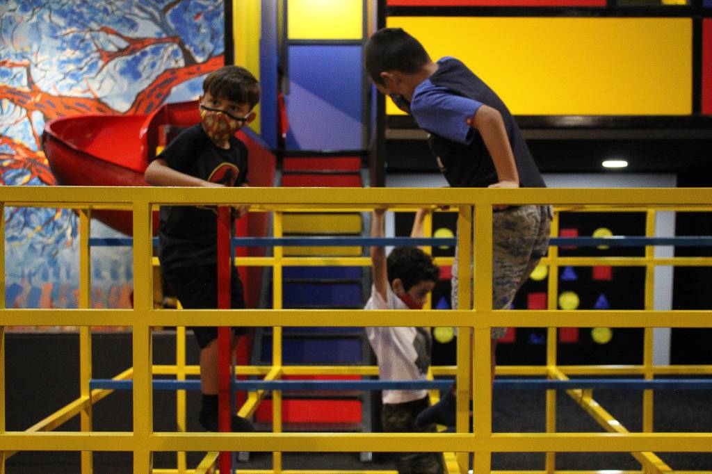 Crianças de máscara brincam nos playgrounds do Museu da Imaginação.