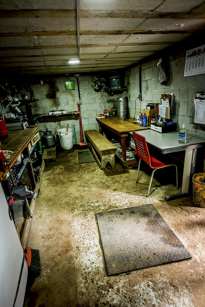 BUNKER_1.JPG Imagem mostra sala escura com utensílios, mesas e cadeiras.
