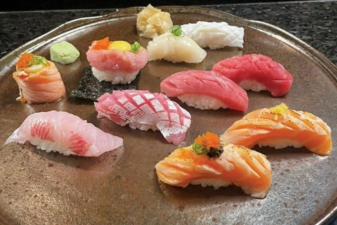Dez peças de sushi dispostas sobre cerâmica de cor marrom
