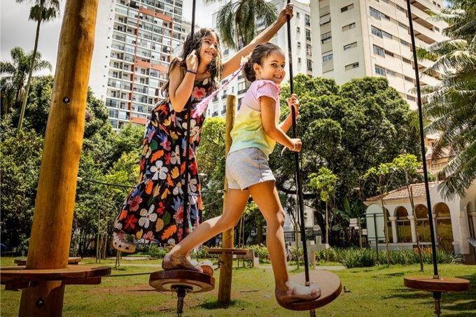 Duas meninas brincam em estruturas de madeira do Parque Augusta.