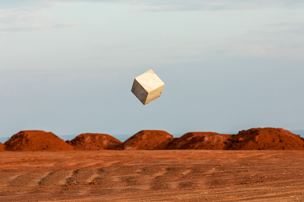 João Angelini_Tudo que é sólido¿ (terraplanagem), 2021_Digital photo_6000 x 4000 px.jpg Obra de João Angelini é uma foto que mostra um quadrado flutuando no céu, acima de um deserto.
