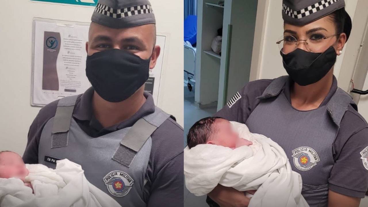Policiais militares seguram um recém-nascido