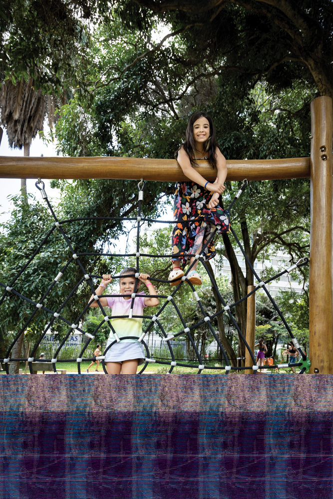 Paula (menor) e Helena(vestido_Foto_Wanezza_Soares-8293-Edit.jpg Paula e Helena, duas meninas, brincam no Parque Augusta. Elas se penduram nas estruturas e sorriem para a foto.