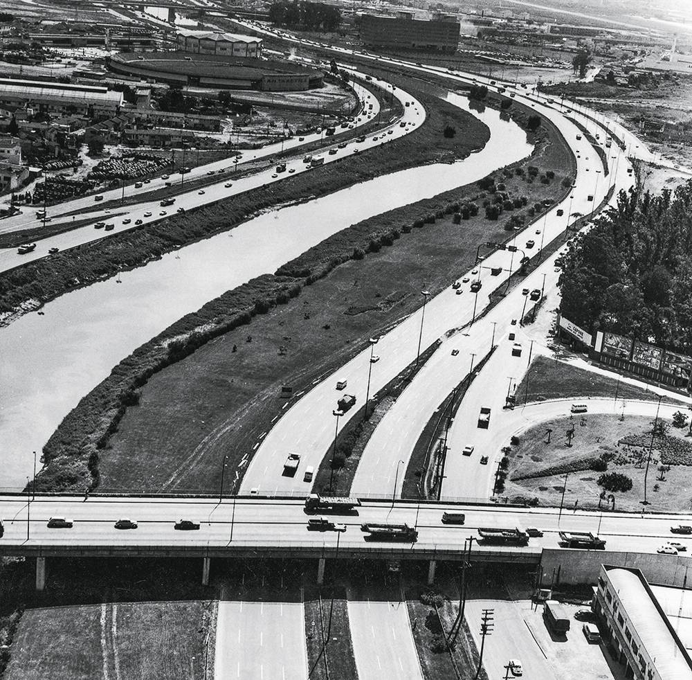 Vista aérea da Marginal Tietê. Imagem mostra estrada ao lado de rio, curvilíneo.