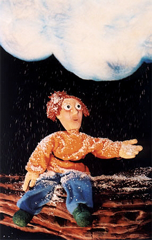 Vovô Créditos Alberto Rocha.jpg Foto mostra um boneco sentado em uma pedaço de madeira enquanto uma nuvem derruba neve em seu colo.