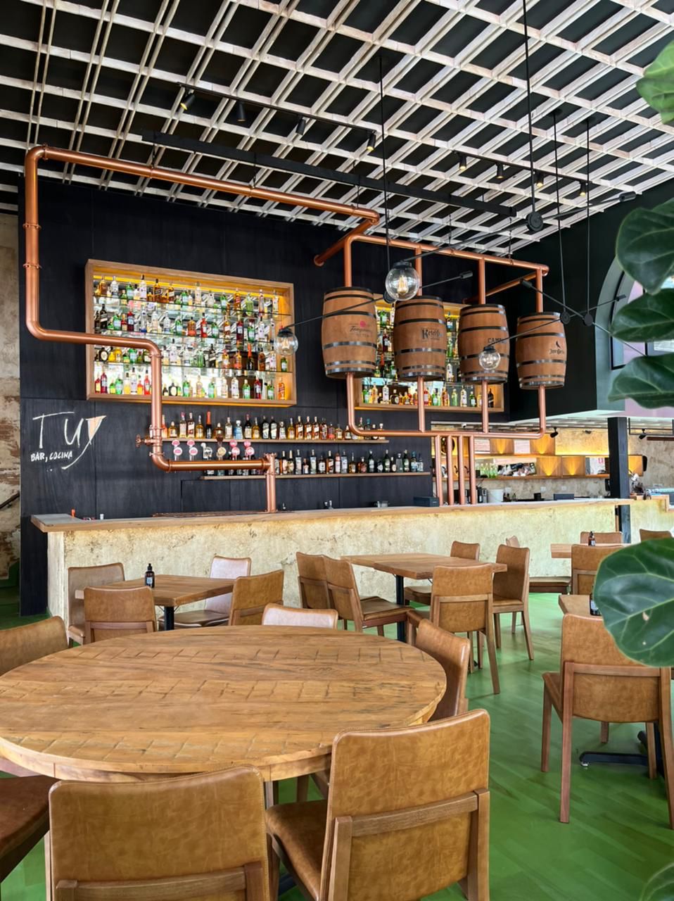 Tuy Bar, Cocina Ambiente de bar com garrafas expostas e barris de madeira como parte da decoração