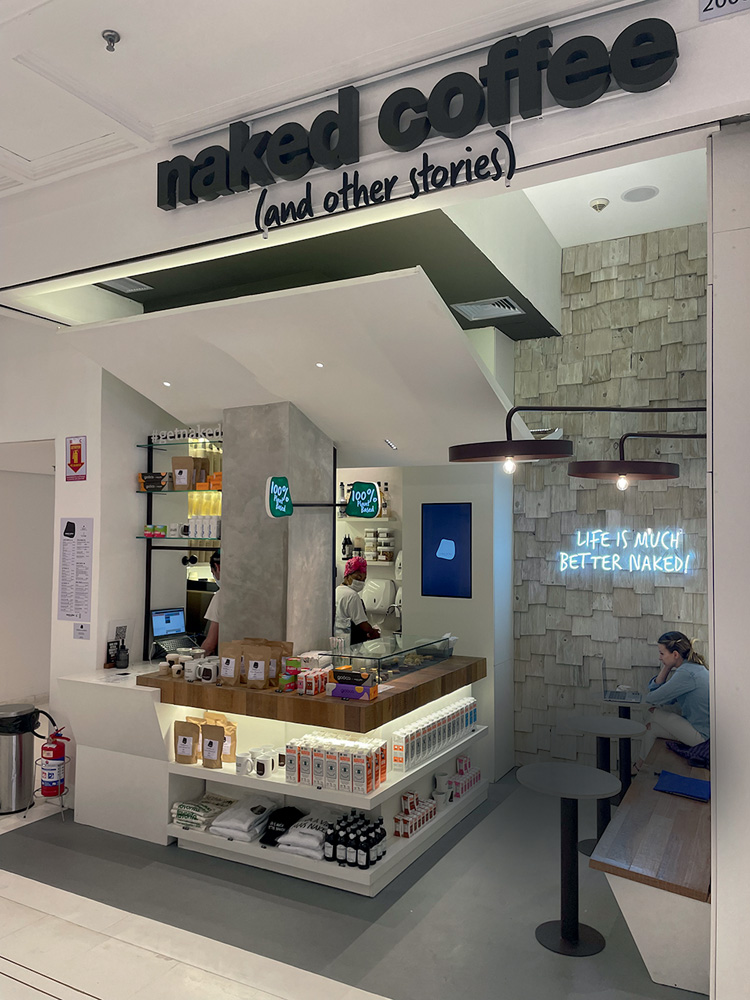 Naked Coffee Cafeteria com decoração minimalista em cores como branco, preto e azul de tom claro