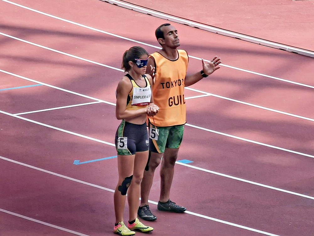 Medalha de prata modalidade 400 MM. Imagem mostra uma mulher e um homem em uma pista de corrida, parados um ao lado do outro.