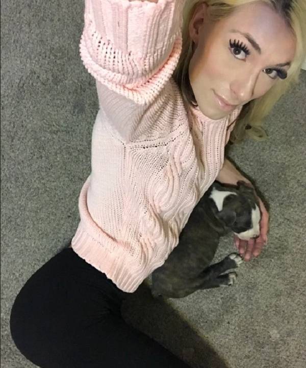 Imagem mostra selfie de Holly, no chão, segurando cachorro pequeno