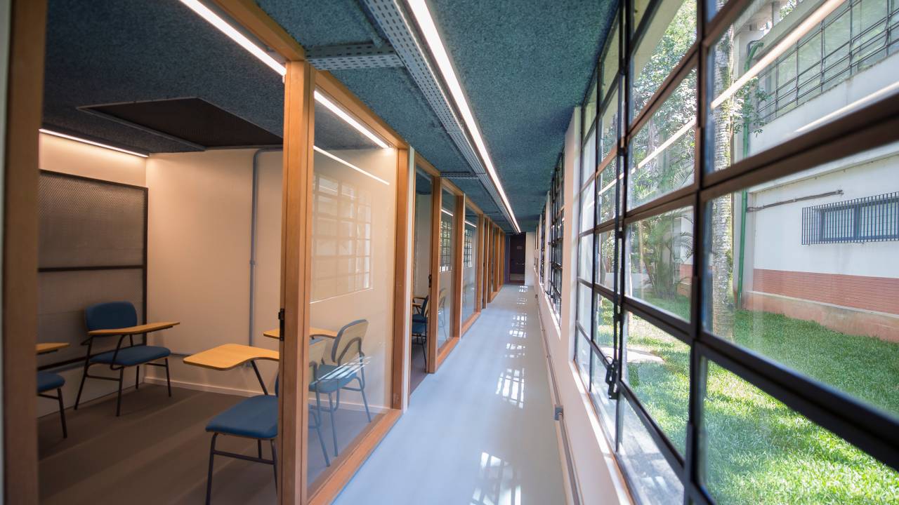 Corredor da USP com vidraças à direita e salas à esquerda.