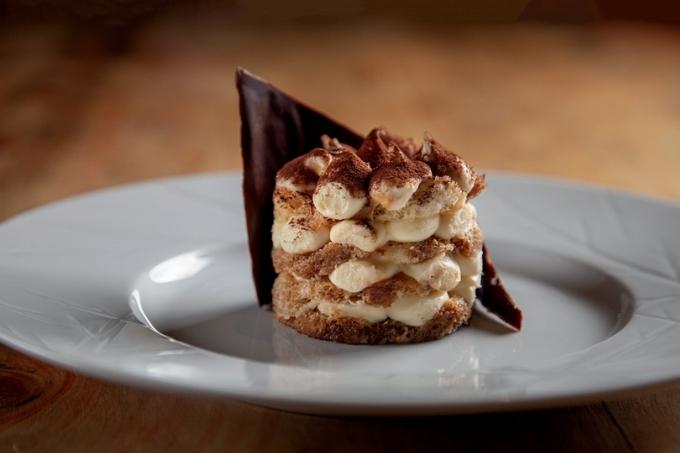 Tiramisu servido em prato raso de louça branca