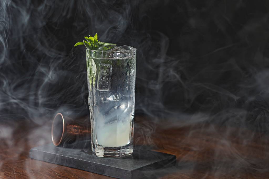 Tivoli – Zodiac Drinks Drinque servido em copo longo envolto em fumaça