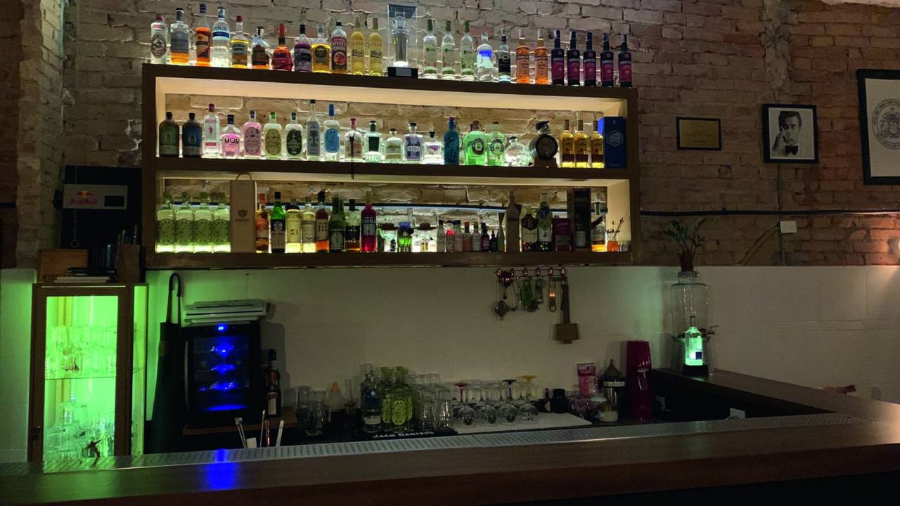 Balcão de bar com utensílios e garrafas à vista
