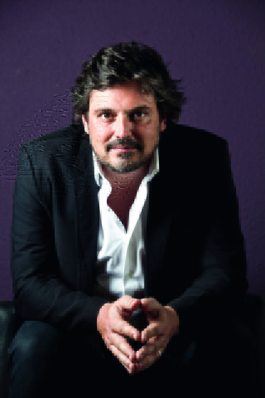 fabiano gullane – credito divulgacao.jpeg Fabiano é um homem branco, de cabelos escuros e barba grisalha. Ele usa um terno e posa sentado com as mãos unidas na frente do corpo para a foto.