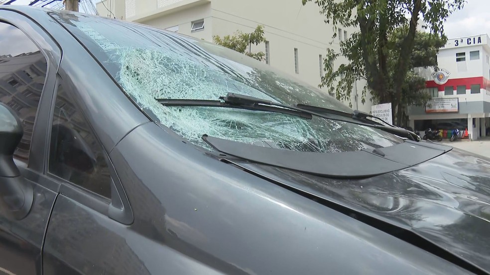 Foto da parte dianteira de um carro. O vidro do automóvel está quebrado