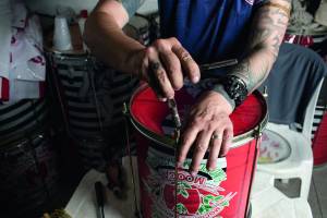 Eduardo Rocha realizando manutenção de instrumentos de percussão no barracão da Mocidade Unida da Mooca.