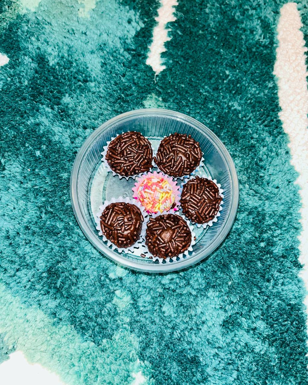 Foto exibe seis brigadeiros em embalagem de plástico.