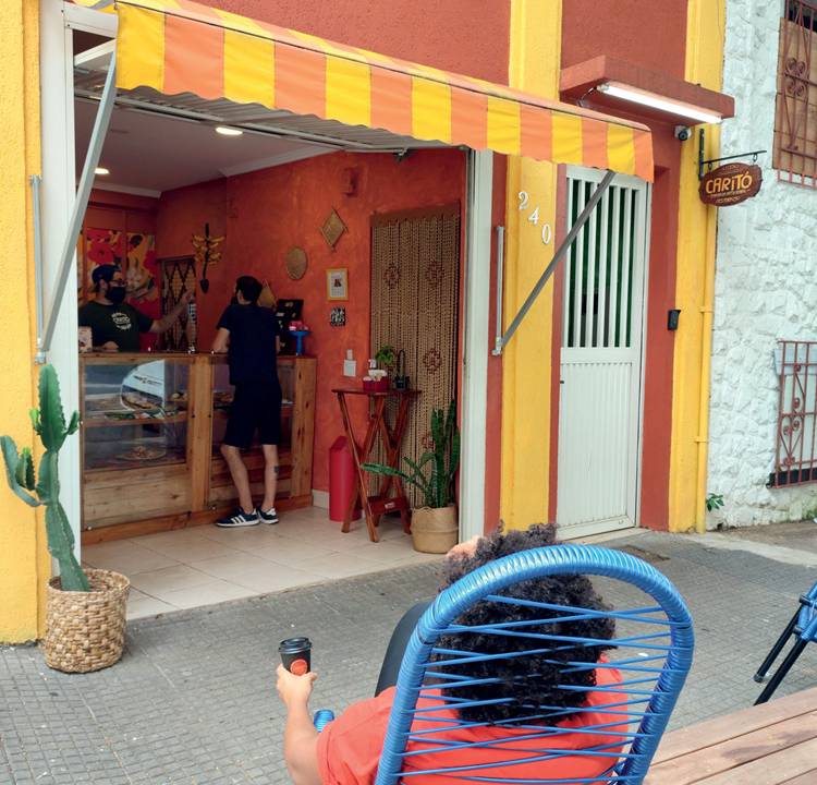 Fachada de micropadaria pintada na cor laranja e com banco para receber clientes