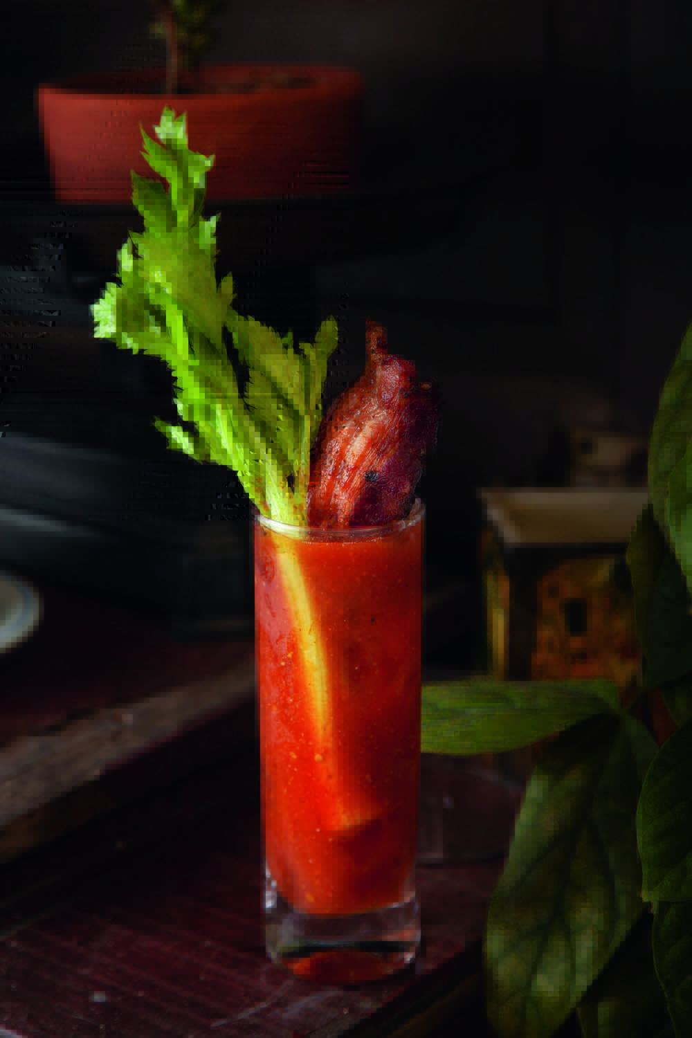 Del Jaguar Drinque de cor avermelhada servido em copo longo guarnecido por um talo de salsão e bacon