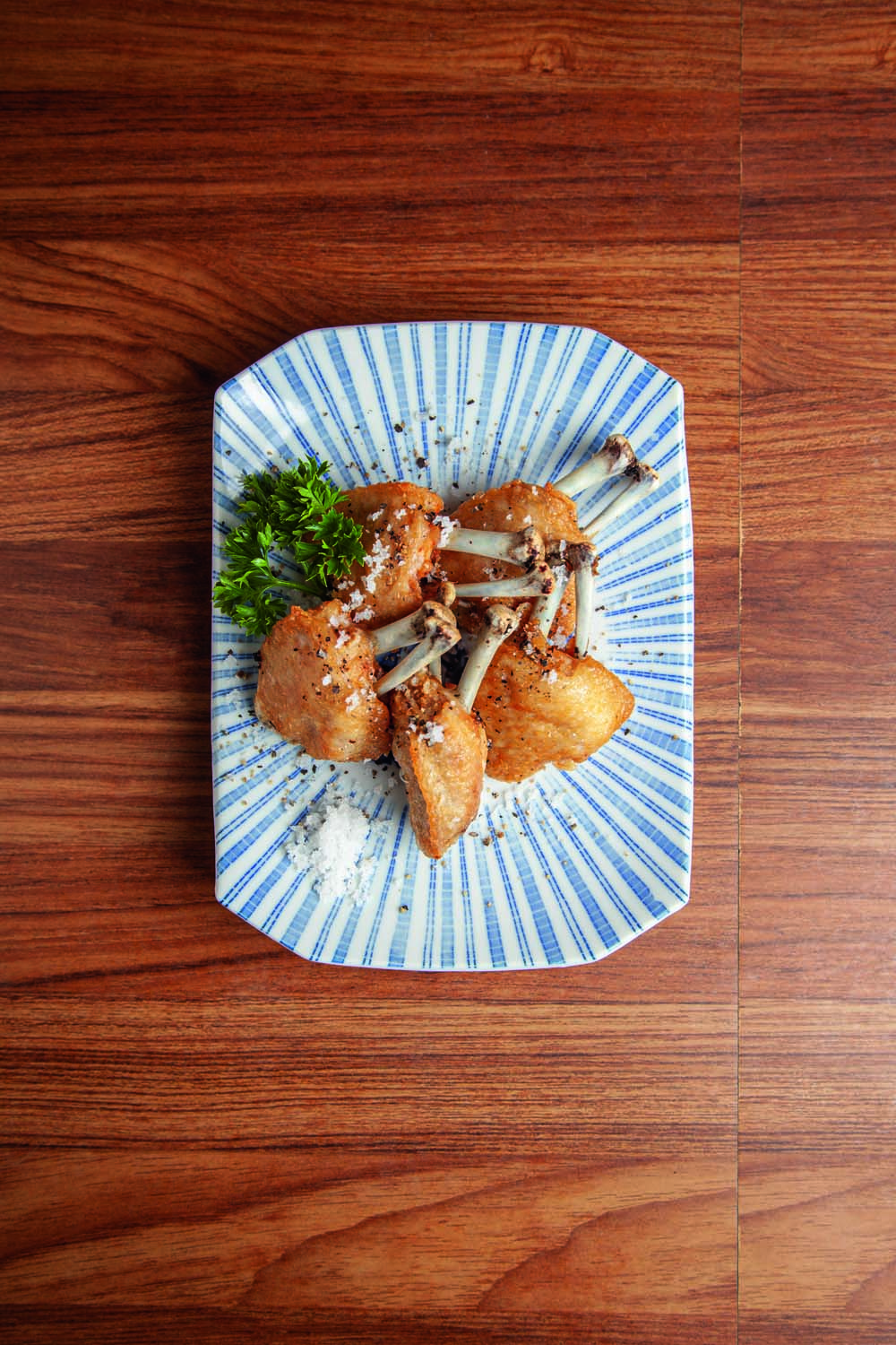 Porção de asinhas de frango sobre cerâmica de cor azul